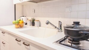 A kitchen with a sink, a stove, and cabinets. - Ben Yehuda By theLight apartment (Tel Aviv)