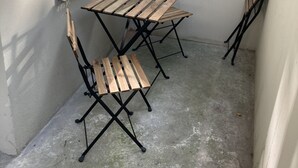 Un pequeño espacio al aire libre con una mesa y dos sillas.