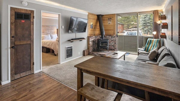 A cozy living room with a fireplace, a television, and a comfortable seating area. - Krystal Villa East 303- Nice, Central to Town (Mammoth Lakes)