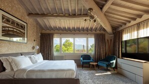 A bedroom with a large bed, a view of a tower through a window, and a television on the right. - Residence  Thym N3003 (Lucca)