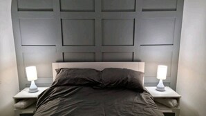 A bed with a dark-colored headboard and two bedside tables with lamps. - Remarkable 3-bed House in Chelmsford (Chelmsford)