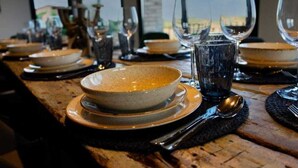 A dining table set with plates, bowls, glasses, and cutlery. - Casa Rural en Cardona (Cardona)
