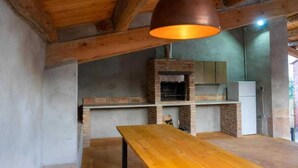 A rustic kitchen with exposed wooden beams, a brick oven, and a wooden table. - Casa Rural en Cardona (Cardona)