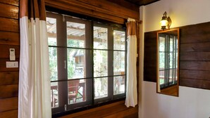 A room with wooden walls and a large window with white curtains. - Ziggy Stardust (Ranong)