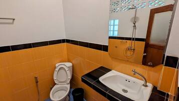 A bathroom with a toilet, sink, and shower.