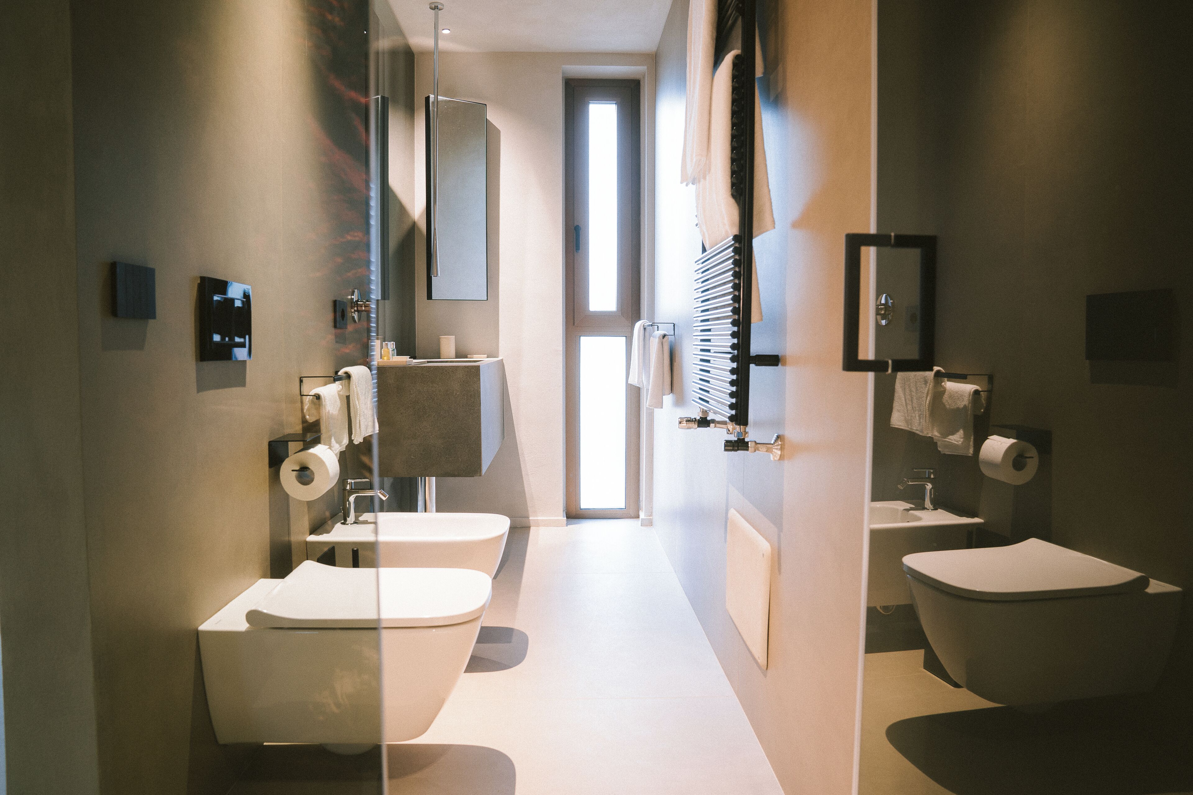 Ein modernes Badezimmer mit Toilette, Bidet und Waschbecken.