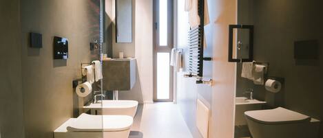A modern bathroom with a toilet, bidet, and sink.