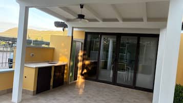 Un patio cubierto con un lavamanos integrado y un ventilador de techo.