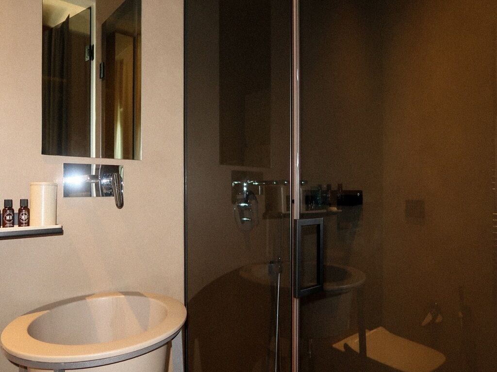 Un bagno con lavandino, specchio e cabina doccia in vetro.