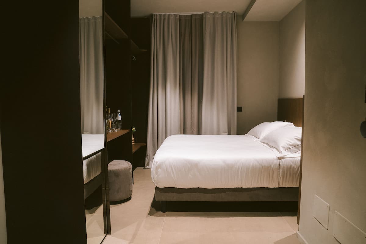 Een slaapkamer met een bed, een bureau en een stoel.