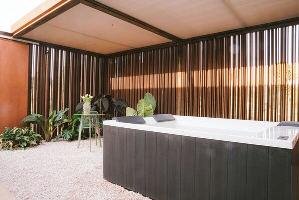 A reception desk with a white top and dark wood paneling, surrounded by plants and a bamboo fence. - Villa Grumolara & Spa (Lamezia Terme)