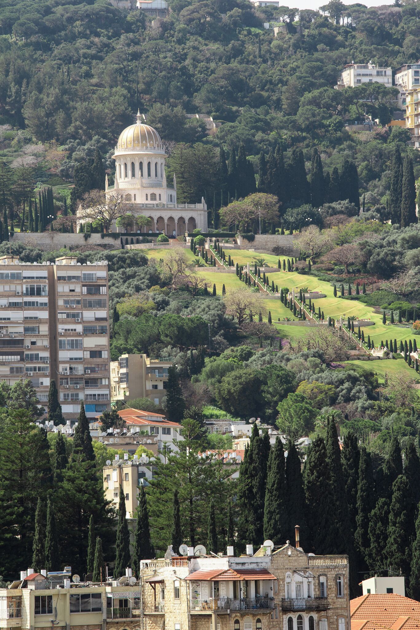 A historic building with a dome, surrounded by a landscaped garden and residential buildings.