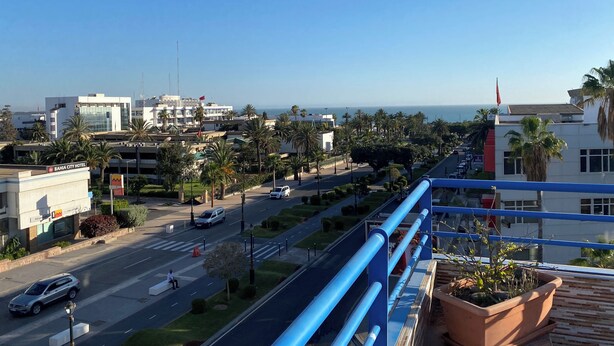 Un paisaje urbano con vista al mar, un hotel llamado BAHIA CITY HOTEL y una carretera con vehículos.