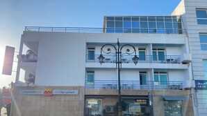 Un edificio de varios pisos con balcones y un farol en la calle.