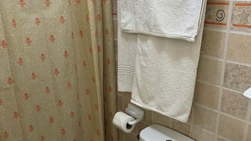 Baño con inodoro, lavamanos y cortina de ducha.