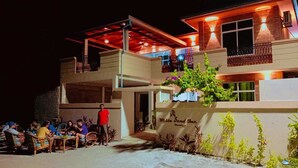 A two-story building with a covered outdoor seating area.