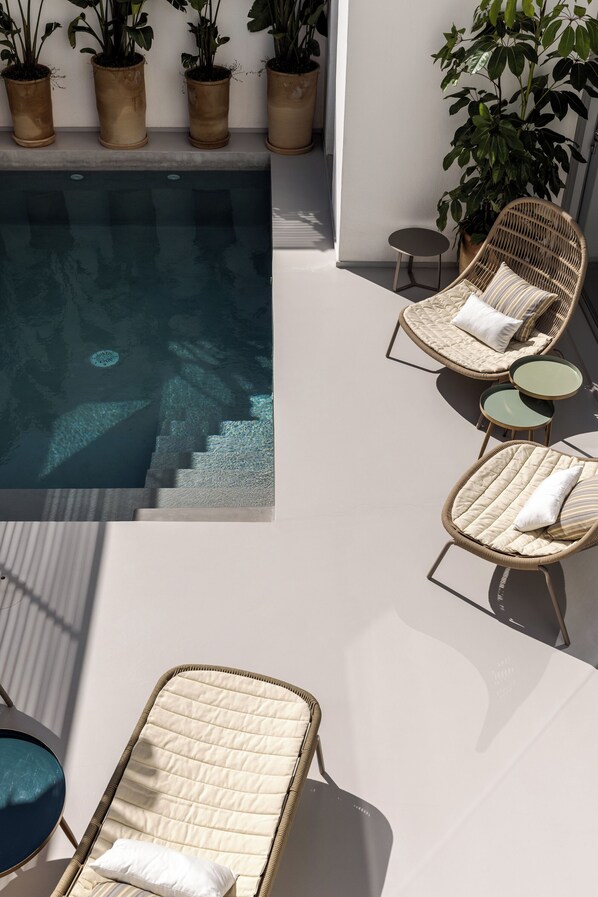 Relax by the pool with comfortable wicker lounge chairs and lush greenery.