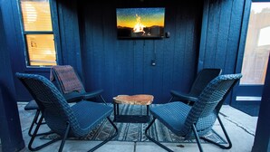 Eine blaue Außenwand, an der ein Fernseher mit einer Szene eines Feuers angebracht ist.