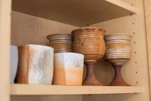 A wooden shelf with ceramic items.