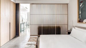 Ein modernes Schlafzimmer mit einem großen Bett, einem Holzschrank und einem verschiebbaren Shoji-Bildschirm.