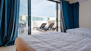 A hotel room with a balcony, two beds, and a seating area with chairs. - Anah 410 2 Bedroom Condo by RedAwning (Playa del Carmen)