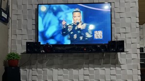 A flat-screen TV mounted on a wall with a geometric pattern.