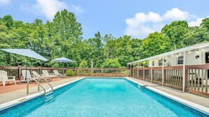 A rectangular swimming pool with a wooden deck and lounge chairs. - 🌊 Lakefront Getaway with 🏖 Saltwater Pool, 🎣 Dock, 🛏 Linens Included (Moneta)
