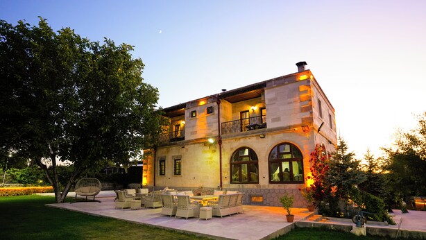 A two-story building with a patio area featuring outdoor furniture. - Cevizli Konak (Nevsehir)