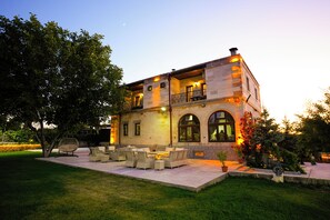A two-story building with a patio area featuring outdoor furniture. - Cevizli Konak (Nevsehir)