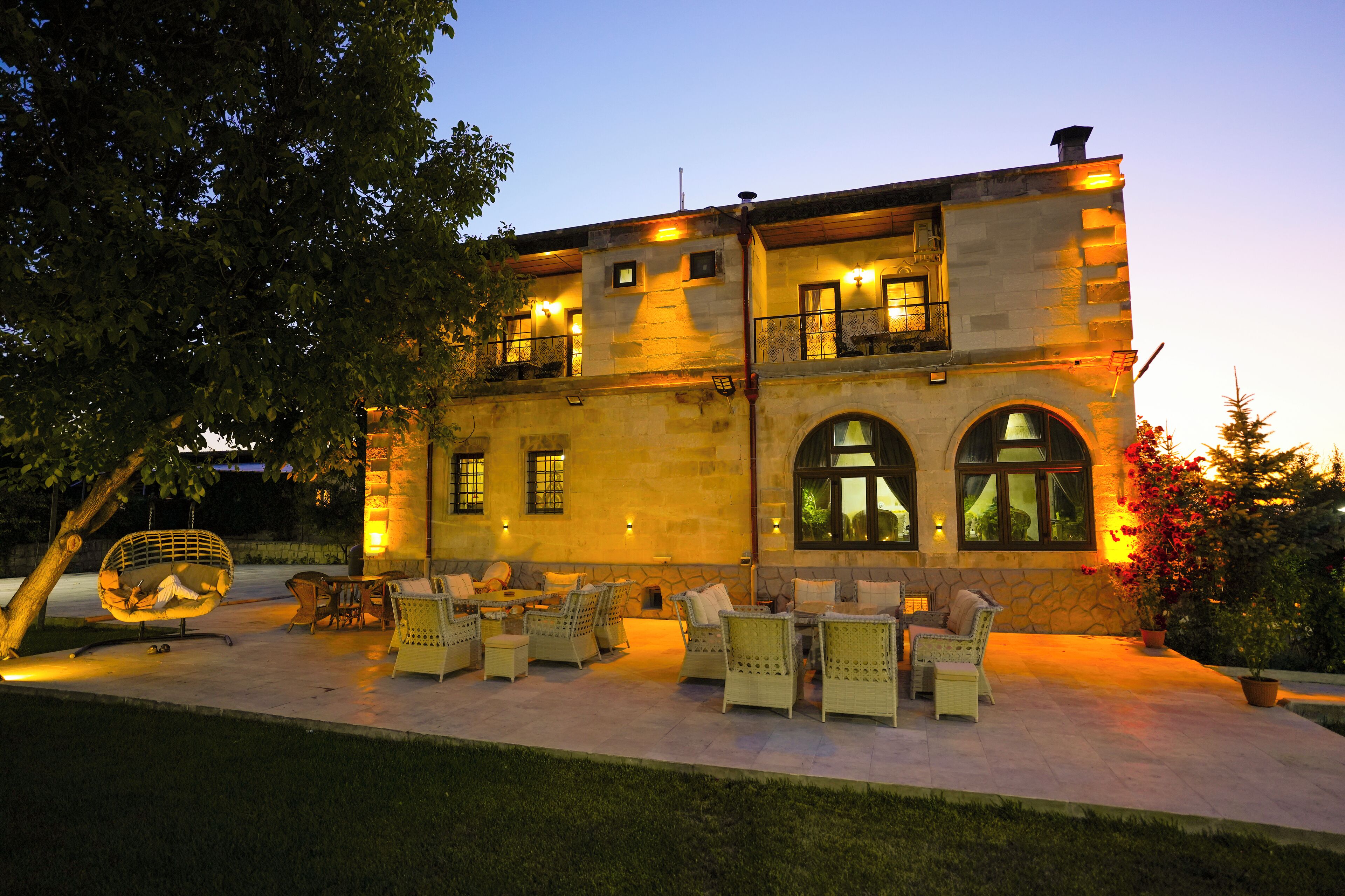 A stone building with outdoor seating and a tree.