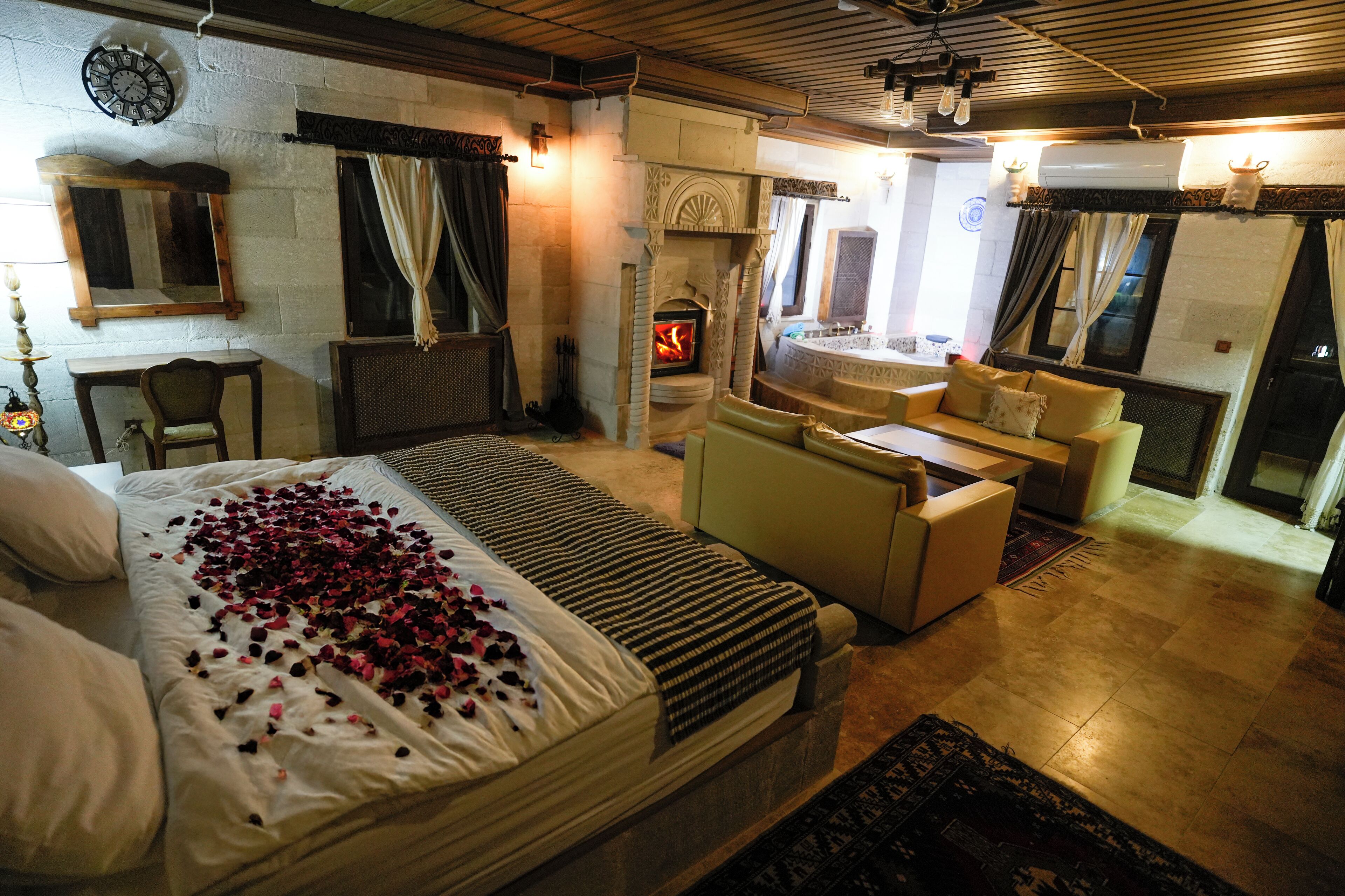 Una habitación acogedora con cama, chimenea, sofá y zona de comedor.