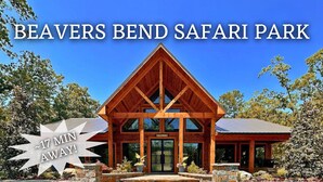 A lodge with a wooden facade and a stone entrance, labeled "Beavers Bend Safari Park." - Secluded Forest Retreat with Game Lounge (Broken Bow)