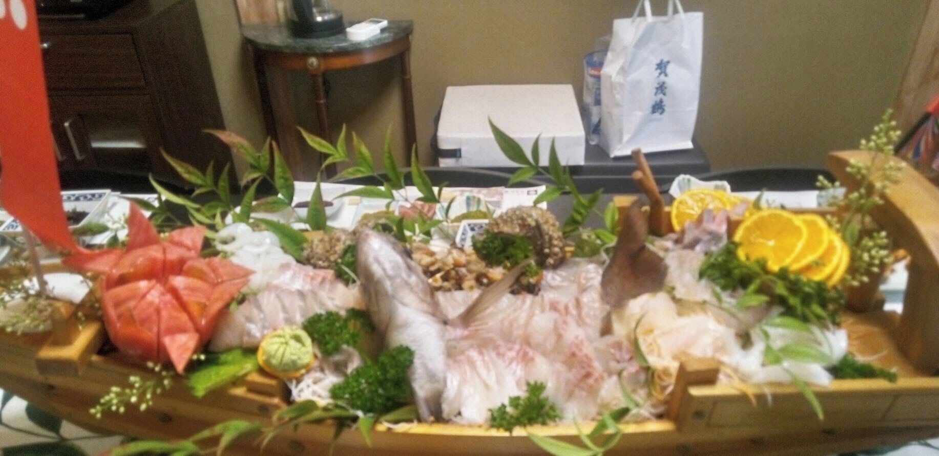 Una bandeja de madera con diversos mariscos y verduras.