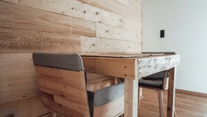 Une table en bois, accompagnée d’un banc, placée contre un mur en bois.