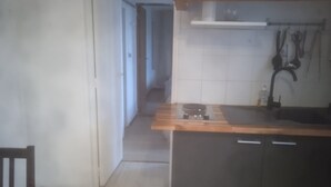 A kitchen with a wooden countertop, a sink, and a stove. There is a hallway leading to another room. - T3 Avec Jardin (Agde)