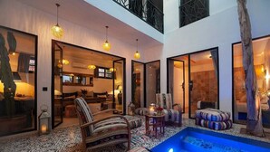 A spacious indoor area with a pool, seating arrangements, and a dining area. - Riad Familial Privatisé au Calme Avec vue sur Marrakech (Marrakech)