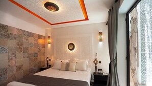 A modern hotel room with a large bed, patterned tiles on the walls, and decorative wall sconces. - Riad Familial Privatisé au Calme Avec vue sur Marrakech (Marrakech)