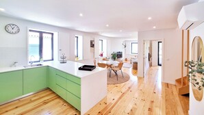 A modern kitchen with green cabinets, a white countertop, and a wooden floor. - Duplex com Jacuzzi, Terraço, & Bbq. Vista Serra (Covilhã)