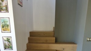 Una escalera de madera con barandilla, que conduce a una plataforma.