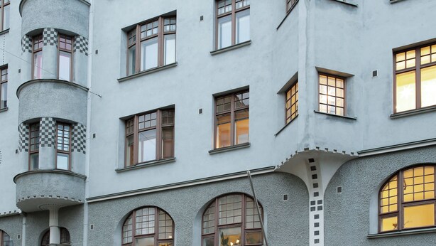 A building with a unique architectural design, featuring a spiral staircase, arched windows, and a prominent entrance. - High-end, quiet, downtown home (Helsinki)