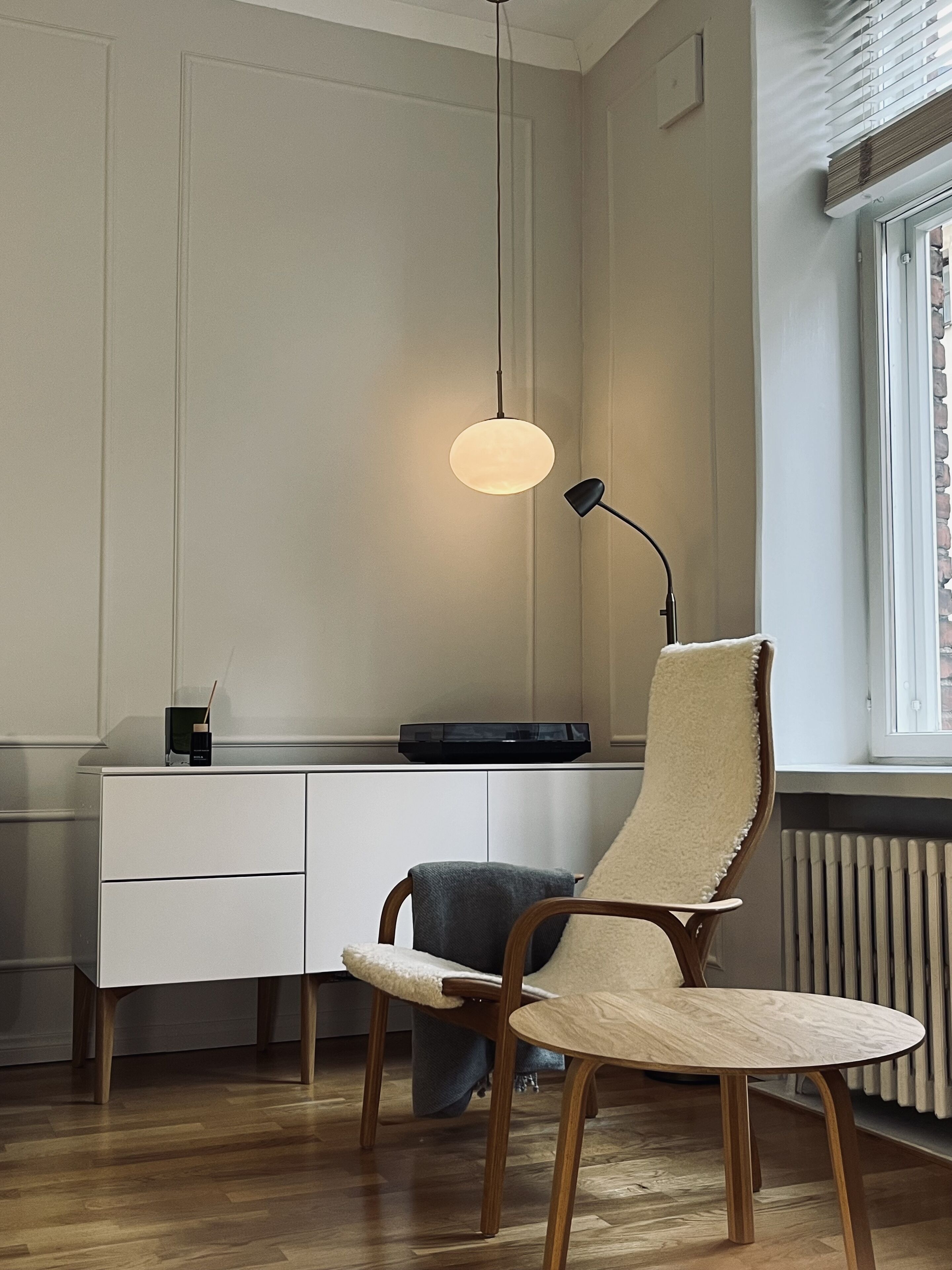 Ein moderner Arbeitsbereich mit Schreibtisch, Stuhl und Pendelleuchte.