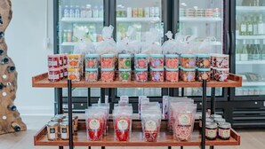 Présentation de divers produits alimentaires dans un magasin, notamment des bocaux et des produits emballés.