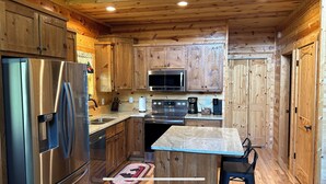 A compact kitchen with wooden cabinets, stainless steel appliances, and a central island.