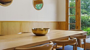 A wooden dining table with a large bowl, wooden chairs, and a wooden ceiling with a woven design. - 4BR House near Casinos & Beach With In Law Suite (Preston)