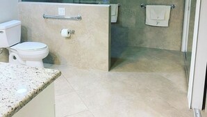 A modern bathroom with a toilet, shower, and sink area. - Large 2 br n loft, 5 miles from downtown Naples 5th Avenue! On golf course (Naples)