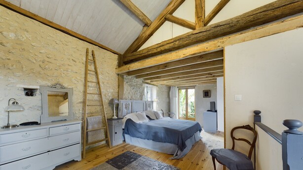 A bedroom with a bed, dresser, mirror, and a chair. - VILLA CHEZ JENNY (Saint Privat en Périgord)