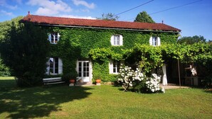 A two-story house with a red-tiled roof, ivy-covered walls, and white-framed windows. - VILLA CHEZ JENNY (Saint Privat en Périgord)