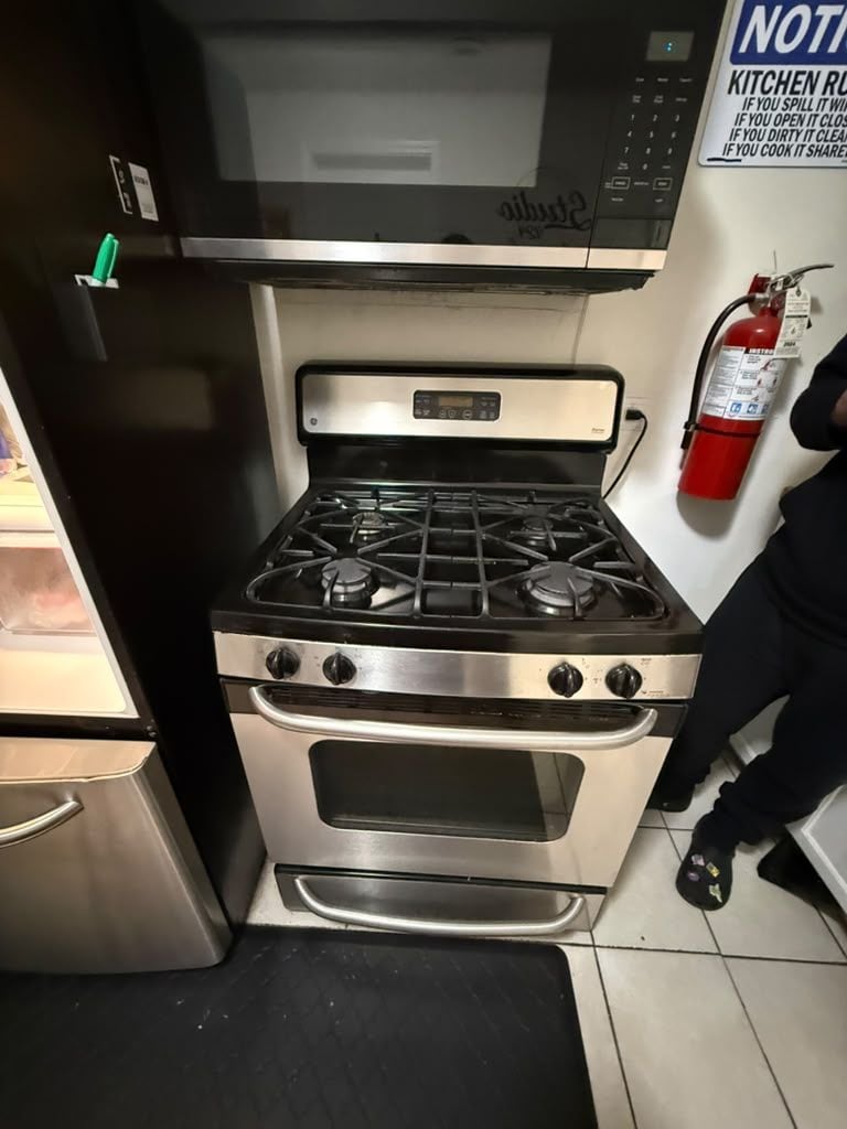 A compact kitchen with a stove, oven, and microwave.