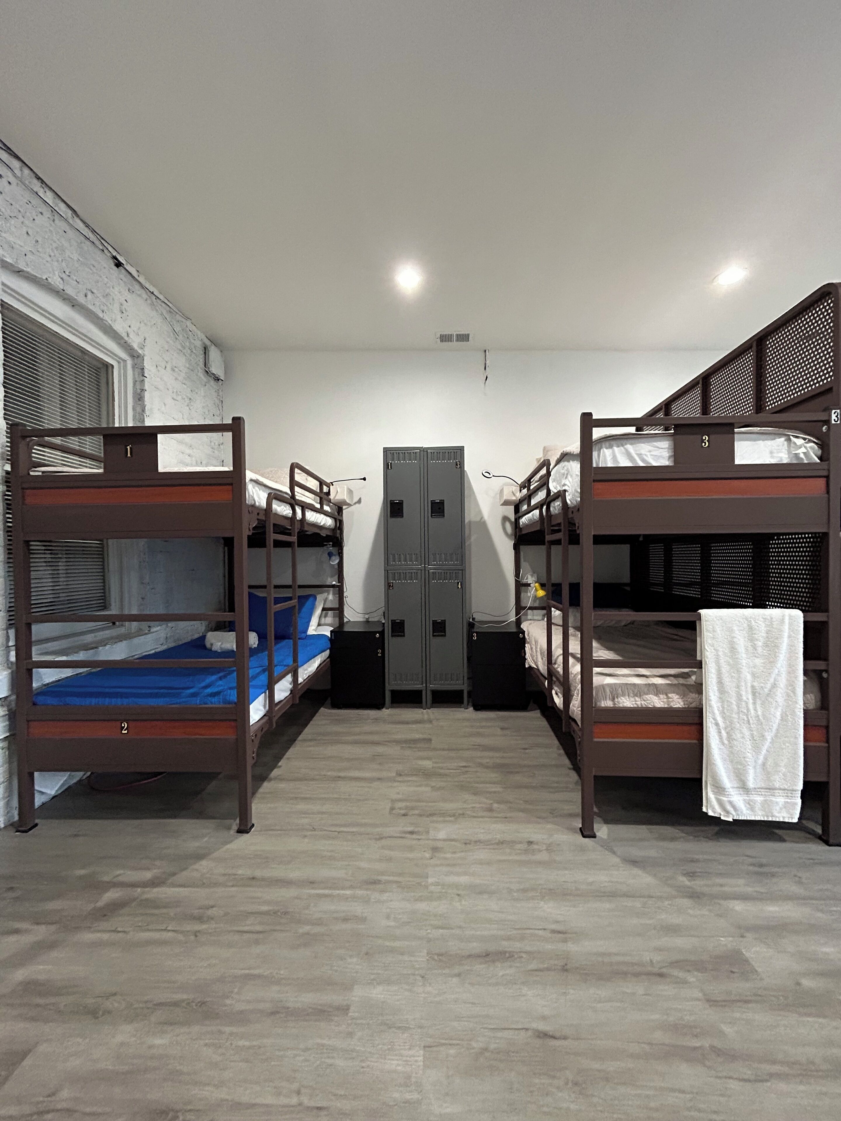 A room with bunk beds, a wardrobe, and a window.