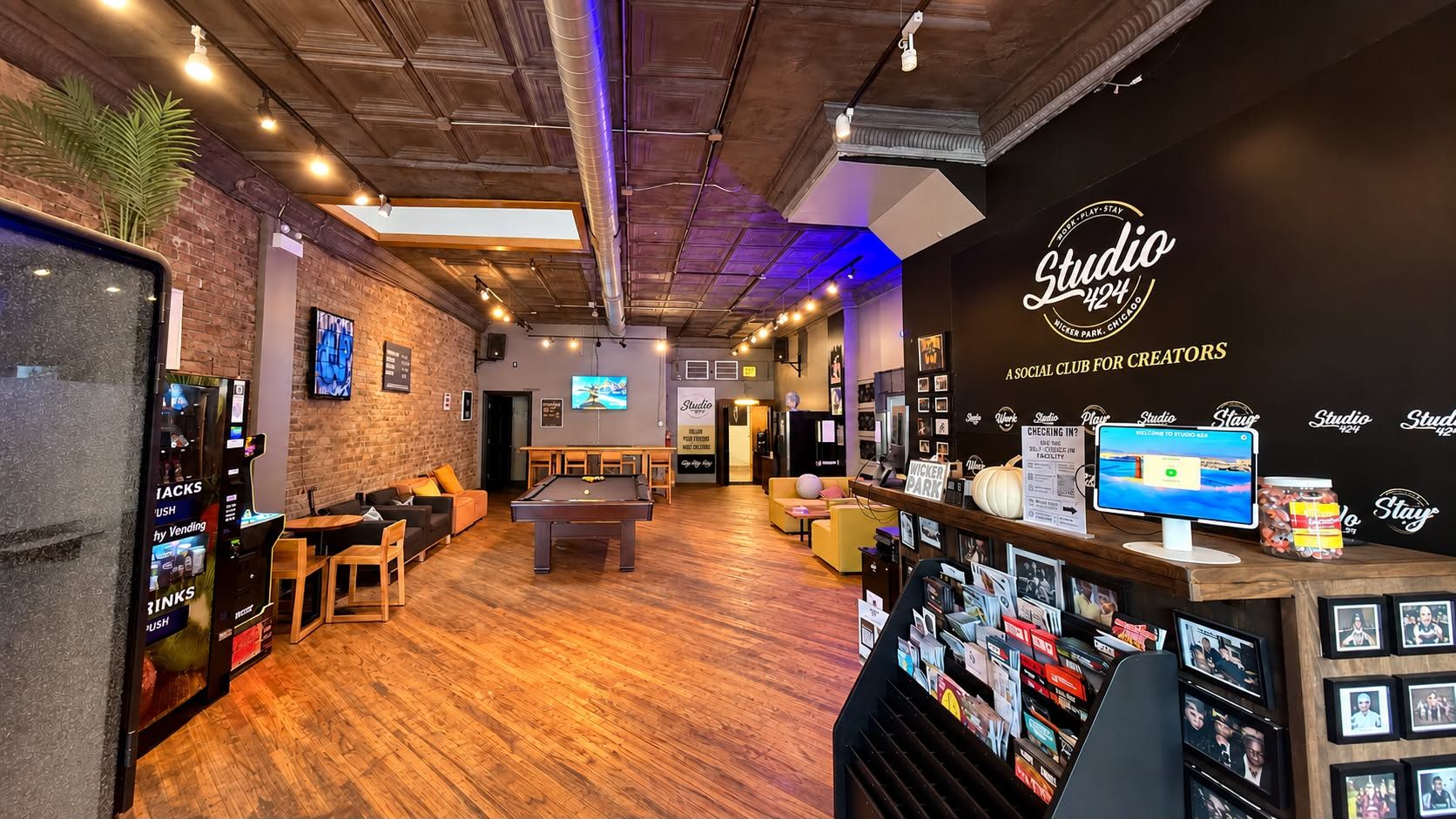 Un espace de détente moderne comprenant une table de billard, des sièges et un distributeur automatique.